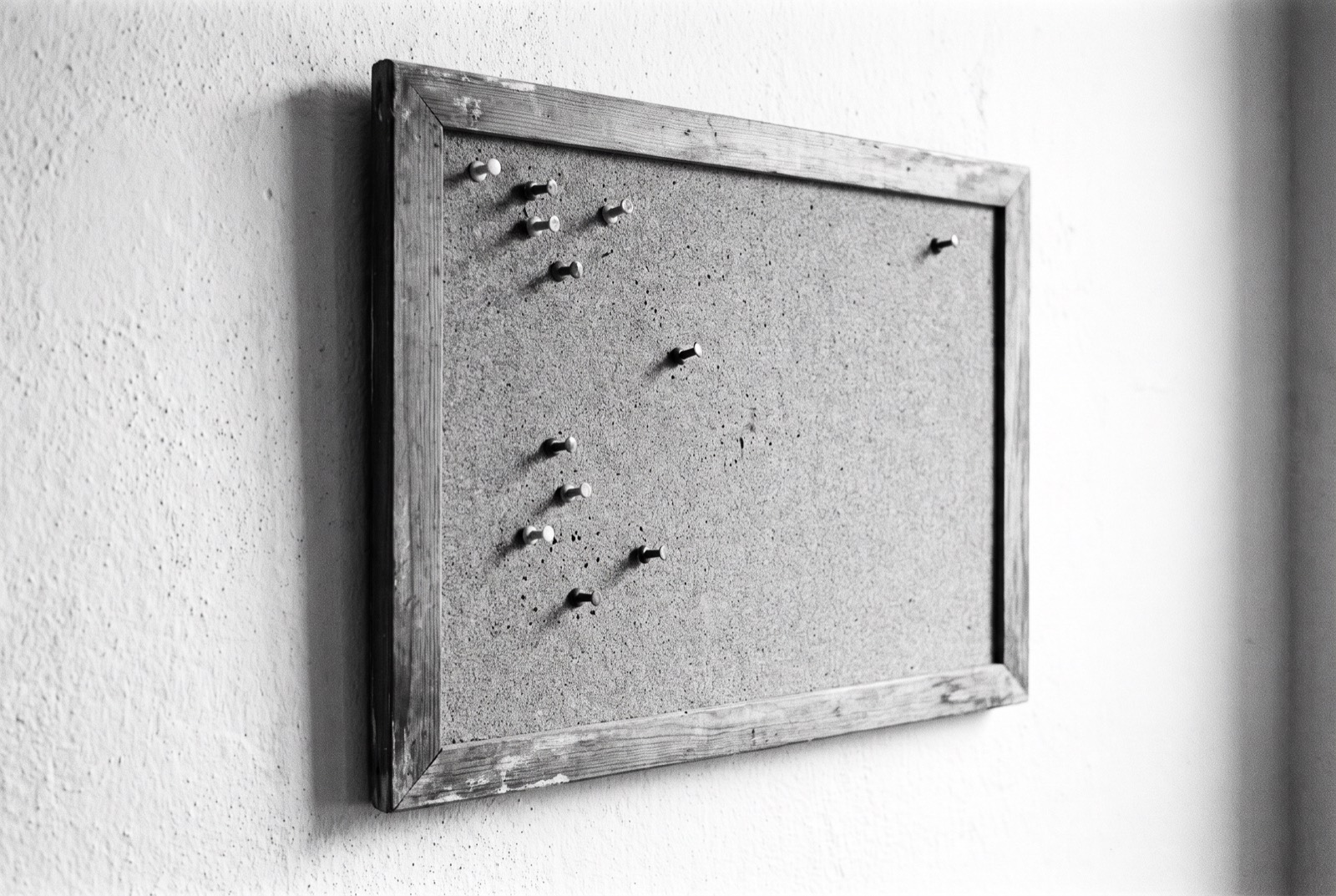 A bare noticeboard with empty pins